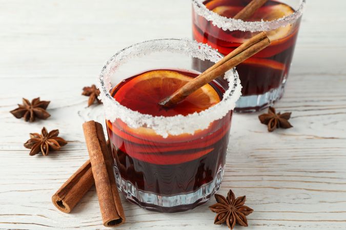 Glasses of tasty mulled wine on wooden background, space for text