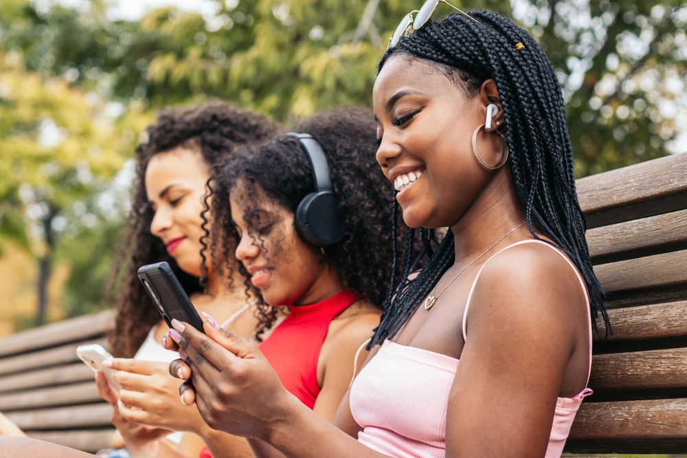 Black Female Friends Enjoying Summer Together and listening to music