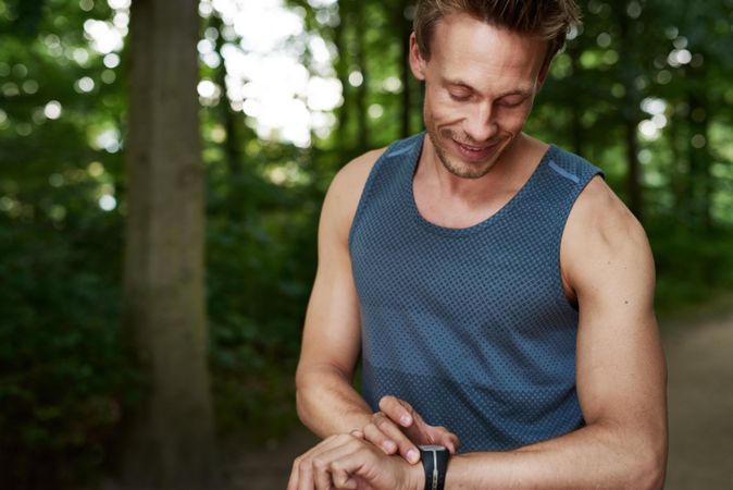 Man checking watch while exercising outside