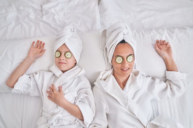 Mother wand son with cucumber slices on eyes