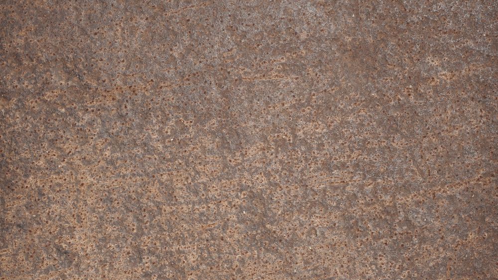 Rusted steel surface with fine pits and rough corroded metallic texture
