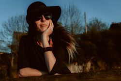 Dreaming stylish woman in sunglasses and hat