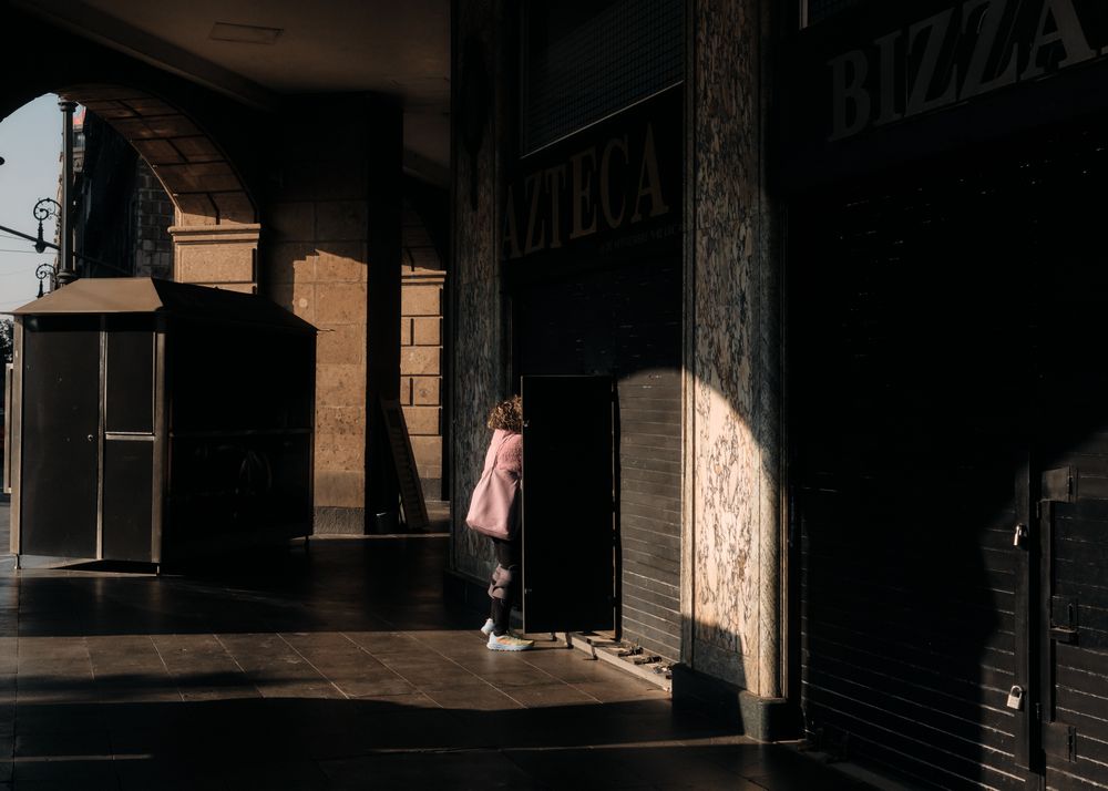 Woman opening shop shutters first thing in the morning