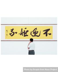 Man in light dress shirt and standing beside kanji text 428N10