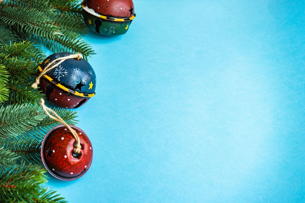 Christmas festive concept of bells and branches on blue background
