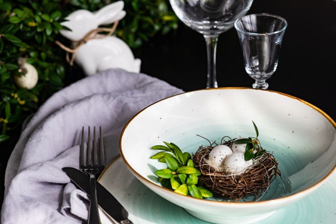 Easter table setting with bird's nest decor in ceramic bowl