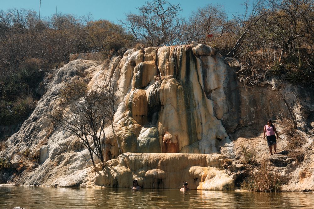 People enjoying mountain spring with petrified waterfall