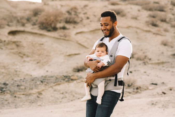 Smiling Black father walking with baby