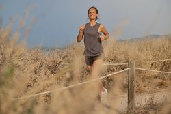 Young woman admiring dry fields while running
