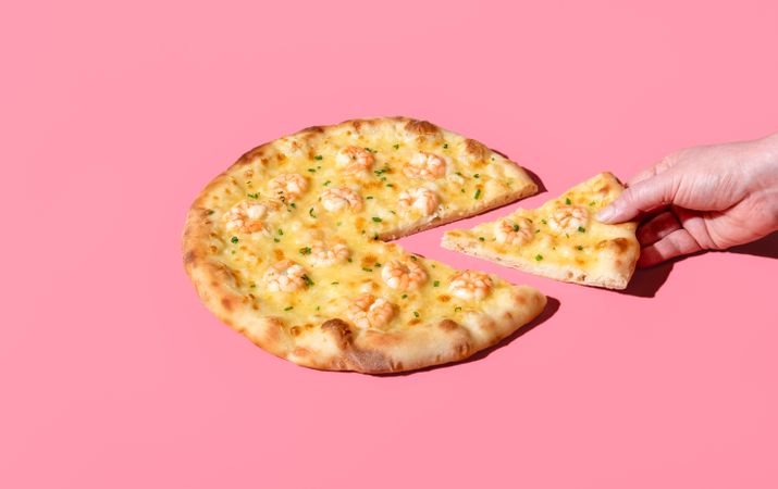 Eating shrimp pizza, minimalist on a pink background