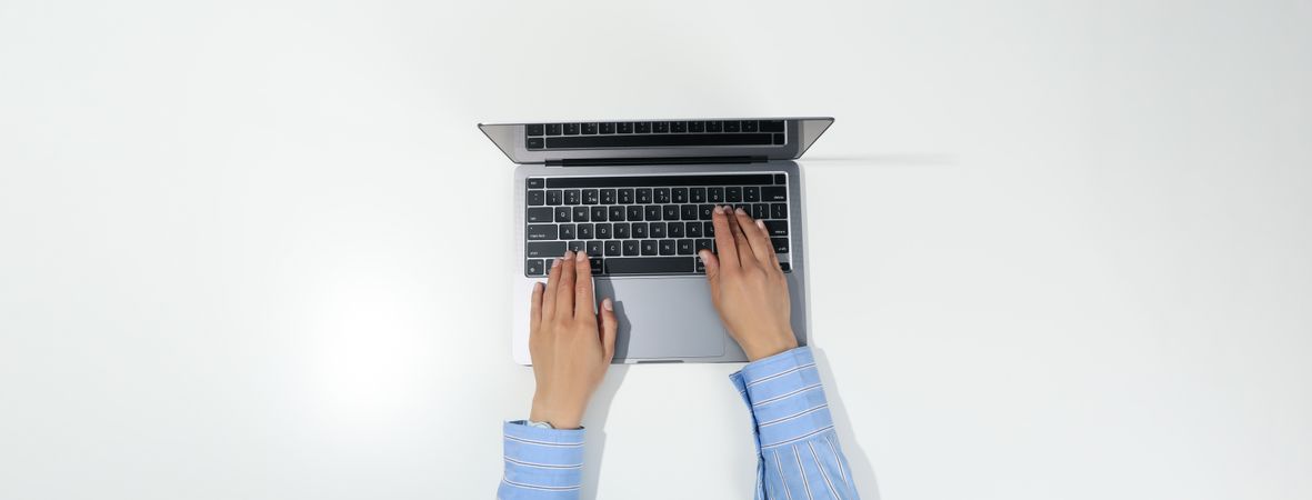 Banner looking down at person using silver laptop on desk with copy space
