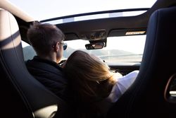 Woman in passenger seat leans on driver