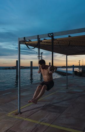 Athletic man balancing on gymnastic rings