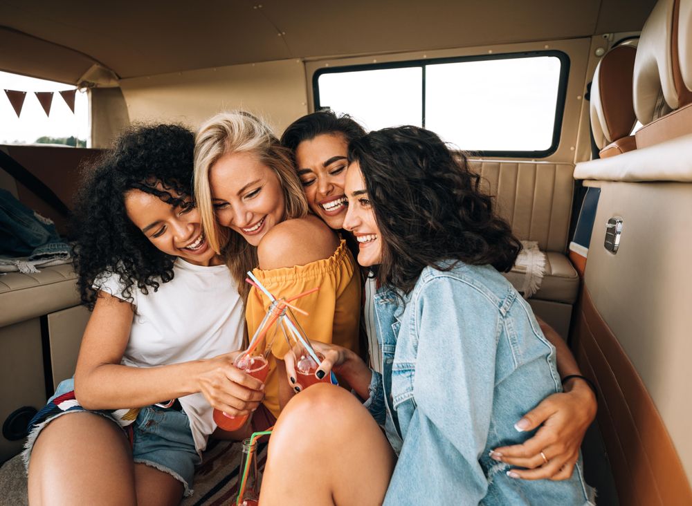 Female friends embracing in the back of a van