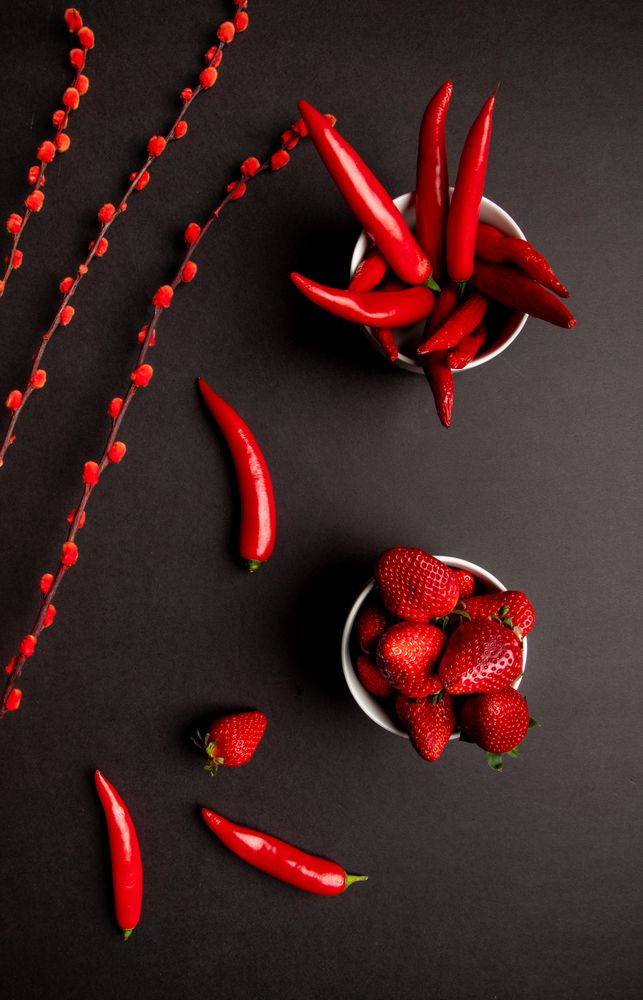 Cloth and branches near peppers and strawberries