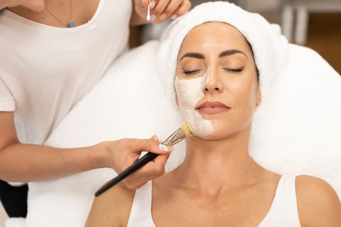 Woman having a relaxing face mask professionally applied at salon