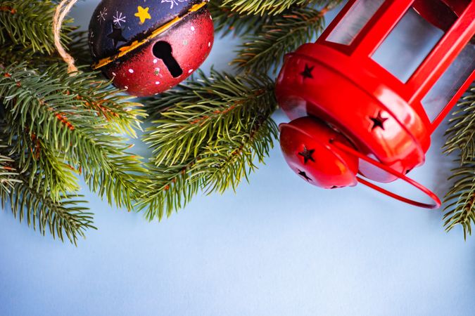 Christmas festive concept of red lantern, bell and branch on blue background