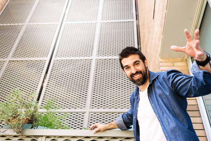 Man smiling leaning off rail outside