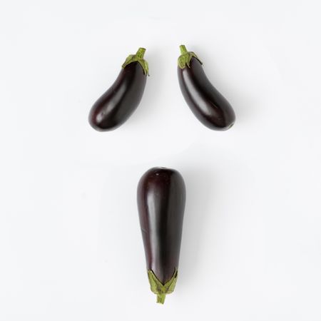 Flat lay of eggplant on light background in haunting face