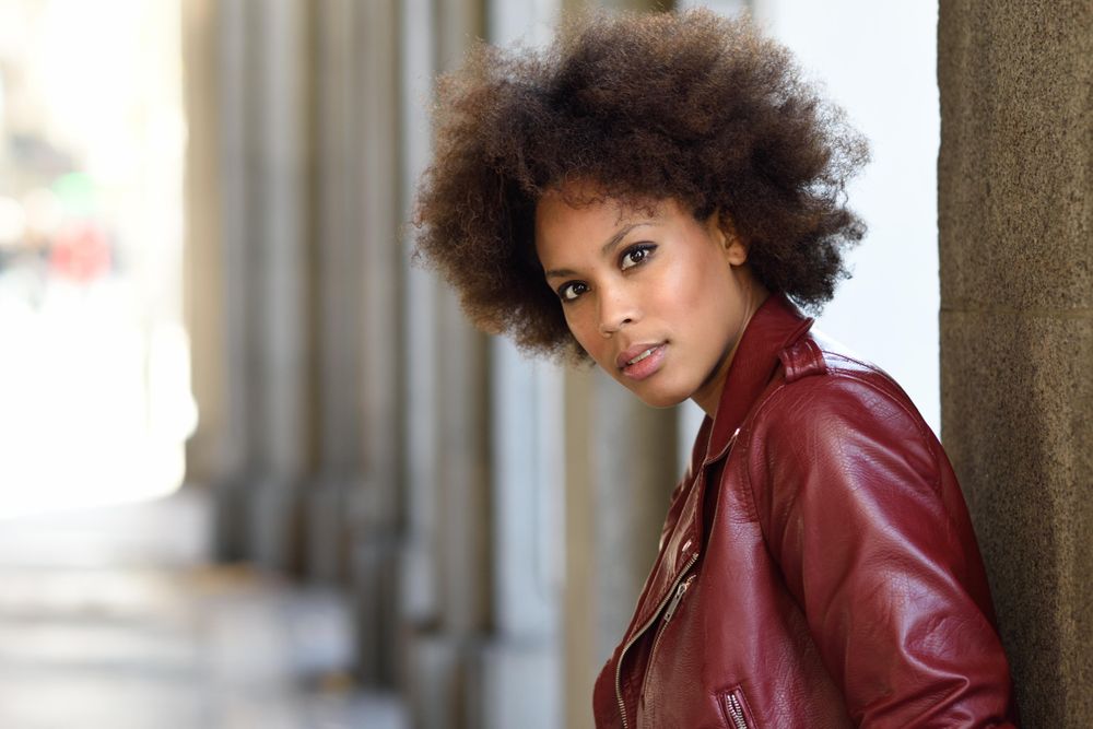 Woman standing in archway in red leather jacket
