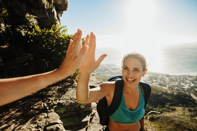 Female hiker giving high five to her friend on mountain top