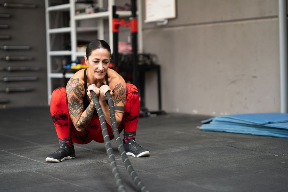 Woman using battle rope in gym