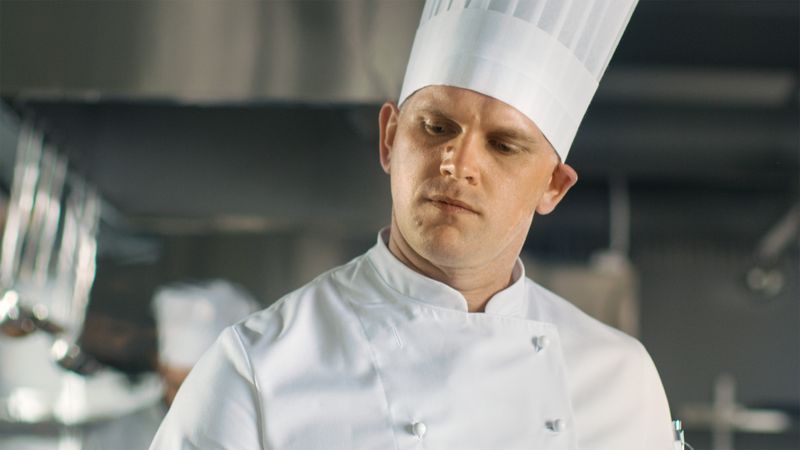 Close-up of a Famous Chef Concentrated on Cooking.
