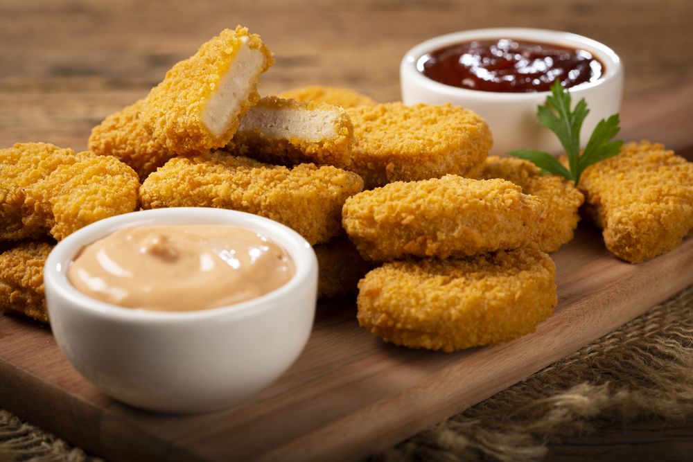 Fried chicken nuggets with ketchp and rose sauce.
