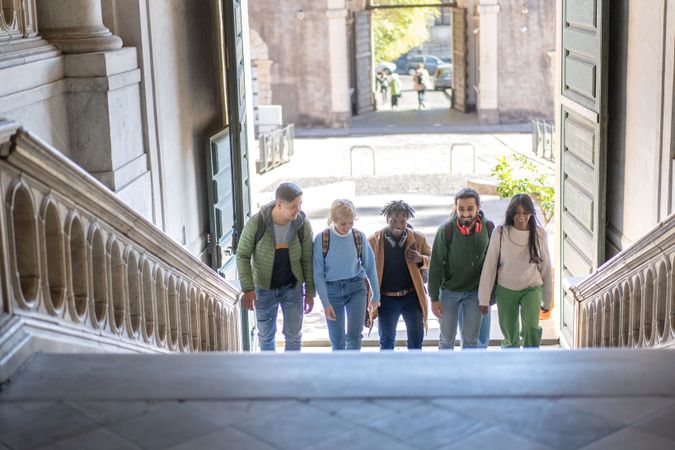 Group of young adults casually walking through a historic city setting