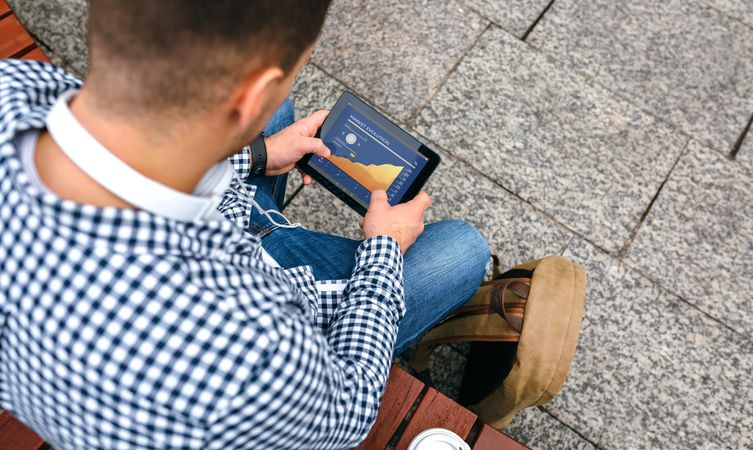 Unrecognizable man looking cryptocurrencies in tablet