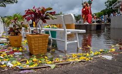 Offerings of fruit and flowers by lake of holy site on cloudy day