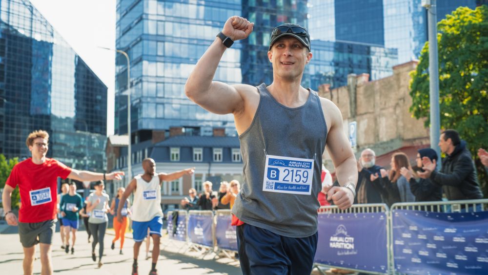 Friendly Happy Male Runner Celebrating Crossing the Finish Line in a Race