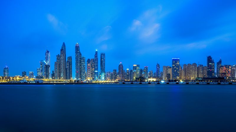 Dubai City skyline across shoreline during night time