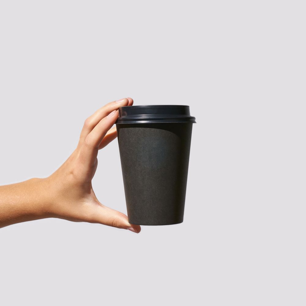 holding a dark coffee cup