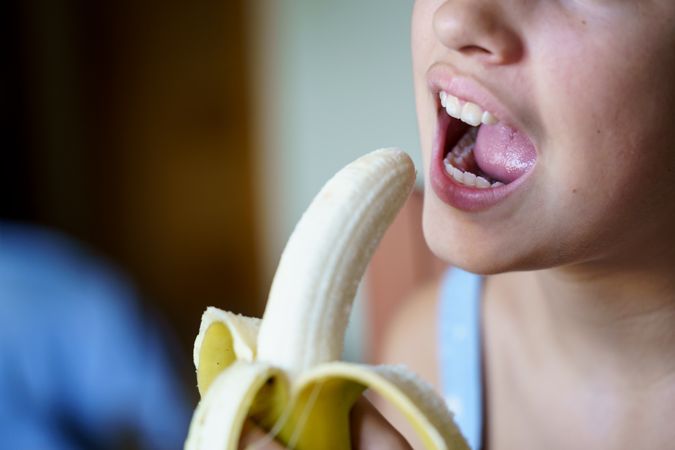 Unrecognizable young girl about to eat yummy peeled banana