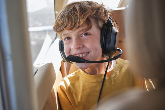 Delighted child smiling during flight in aircraft on sunny day