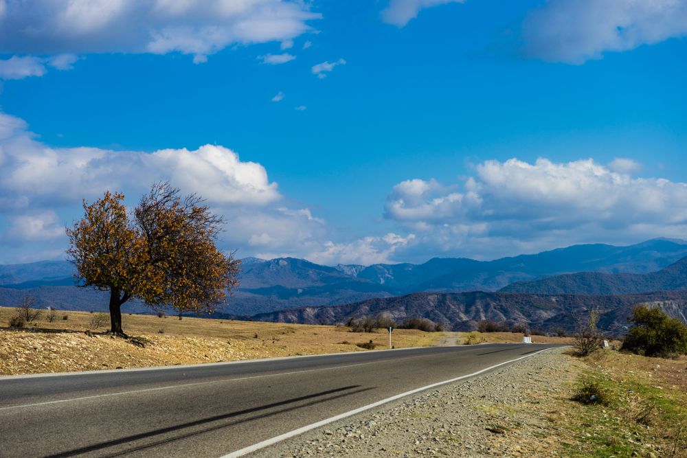 Autumnal Georgian mountain road landscape in Gombori pass with blue sky