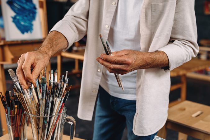 Man choosing which paint brush to use for his work