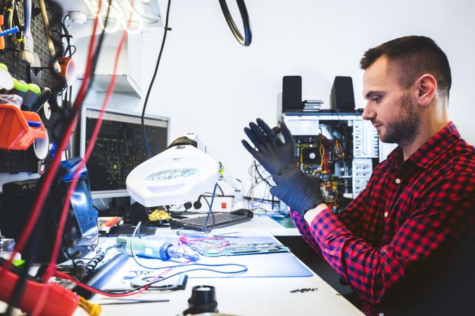 Man repairing motherboard at workplace