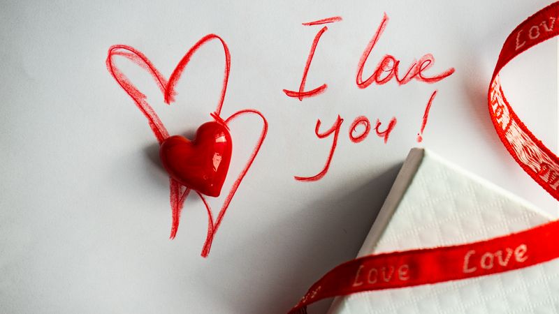 Valentine Day holiday concept with "I love you" written on paper with giftbox and heart ornament