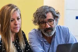 Serious coworkers working on laptop in office