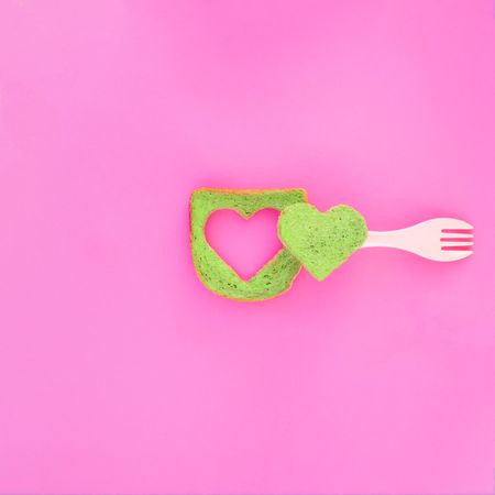 Green bread with heart piece cut in the center and plastic fork