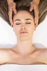 Young woman receiving a head massage in a spa center