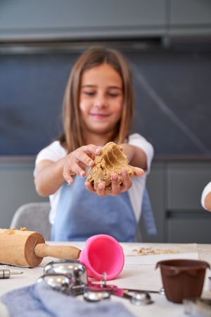 Positive girl making cookie dough
