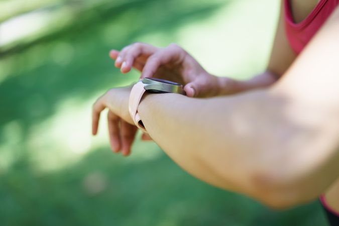 Exercising woman combines fitness with advanced technology, using a smartwatch to monitor her activities