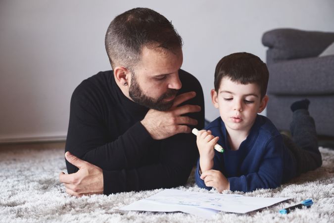 Father and son drawing on floor