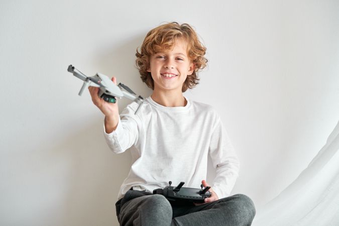 Smiling kid rejoicing toy drone