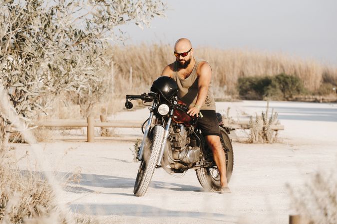 Serious male driving motorcycle in forest