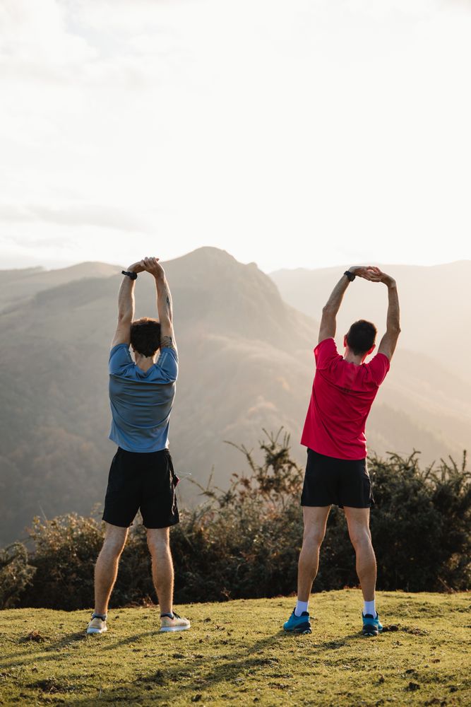 Sportsmen stretching after running in mountains