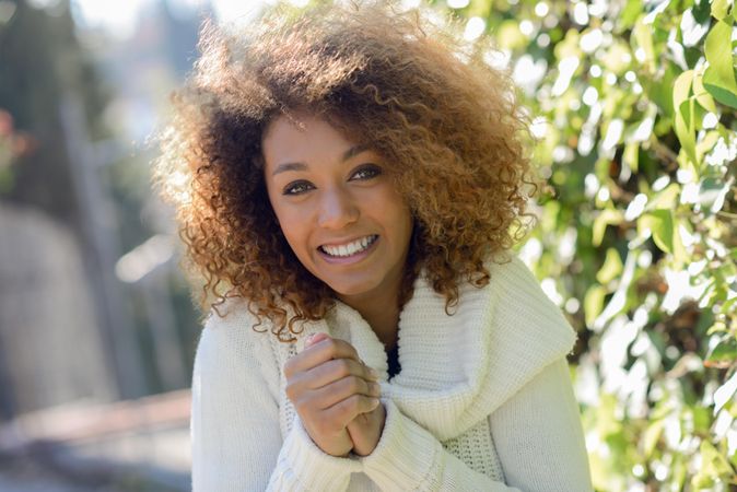 Smiling woman keeping her hands warm wearing sweater outside